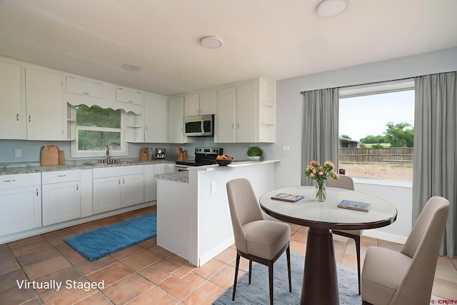 6038 Townsend Rd, Delta, CO 81416 - kitchen featuring open shelves, appliances with stainless steel finishes, light countertops, and a peninsula