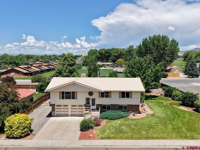 2343 Oldham Way, Montrose, CO 81401 - raised ranch with driveway, an attached garage, and a metal roof