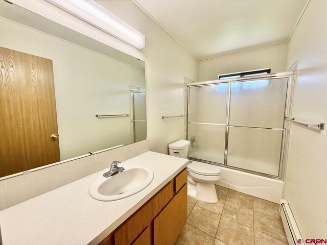 2343 Oldham Way, Montrose, CO 81401 - full bath featuring a baseboard heating unit, vanity, bath / shower combo with glass door, and tile patterned floors