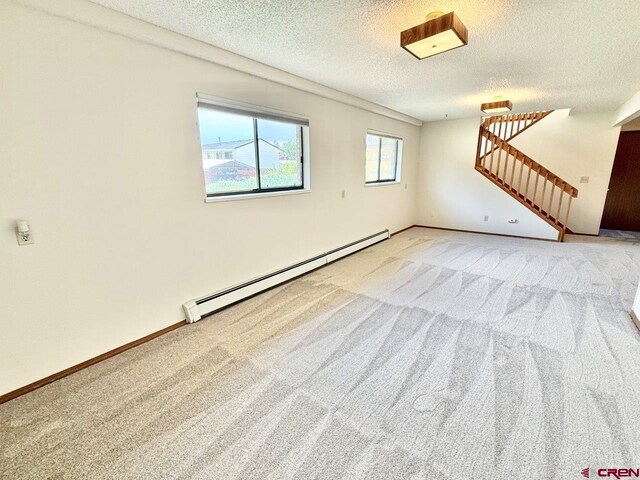 2343 Oldham Way, Montrose, CO 81401 - spare room with baseboard heating, carpet flooring, a textured ceiling, and stairs