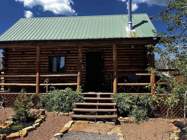 1165 Timber Ridge Rd, Montrose, CO 81401 - view of front of house with log exterior, a metal roof, and covered porch