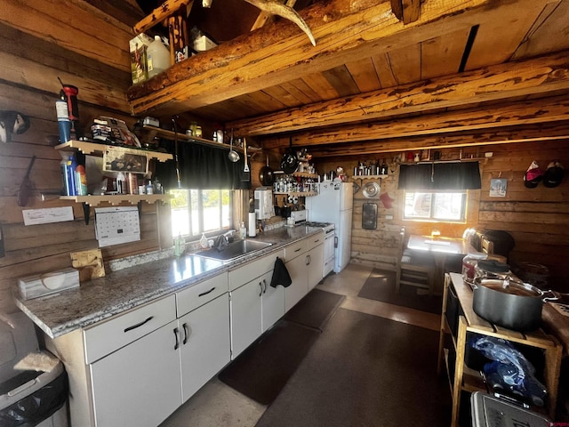 1165 Timber Ridge Rd, Montrose, CO 81401 - kitchen with wood walls, stove, white cabinetry, open shelves, and freestanding refrigerator