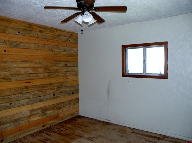 27793 Bb Rd, Nucla, CO 81424 - unfurnished room with ceiling fan, wood finished floors, a textured ceiling, and wood walls