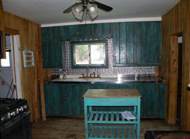 27793 Bb Rd, Nucla, CO 81424 - kitchen with black range with gas cooktop, a ceiling fan, and wood walls