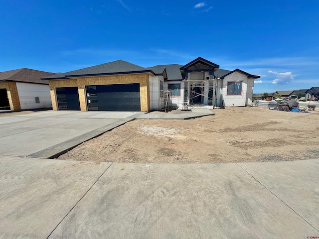 1508 Criterion St, Delta, CO 81416 - unfinished property featuring a garage, concrete driveway, and brick siding