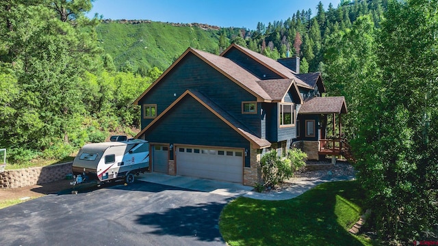 95 Ute Pass W, Durango, CO 81301 - view of front of house featuring driveway, a forest view, a front yard, and a chimney