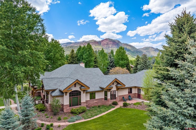 435 Red Rock Rd, Durango, CO 81301 - view of front of home featuring stucco siding, a mountain view, a front yard, stone siding, and a chimney