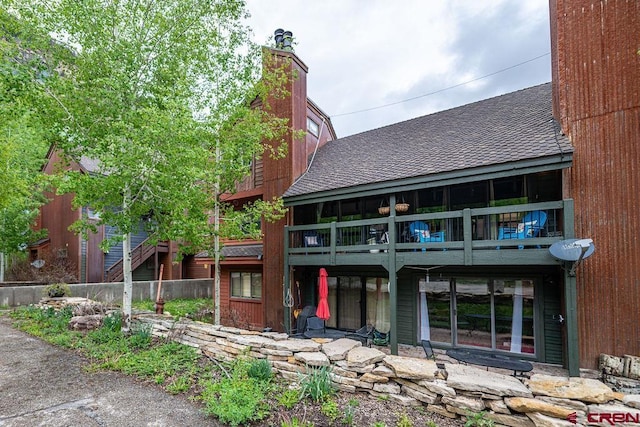 166 Yankee Girl Ct Unit 313, Durango, CO 81301 - back of house featuring roof with shingles, a chimney, and a balcony