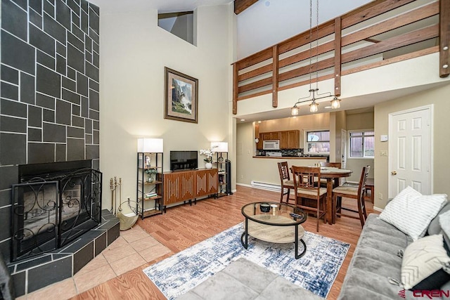 166 Yankee Girl Ct Unit 313, Durango, CO 81301 - living area with a towering ceiling, a baseboard heating unit, light wood-style flooring, and a fireplace