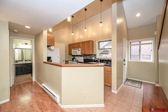 166 Yankee Girl Ct Unit 313, Durango, CO 81301 - kitchen featuring white appliances, a baseboard heating unit, brown cabinets, pendant lighting, and tasteful backsplash