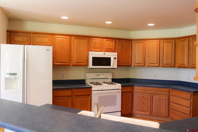 67 Gleneagles Dr, Durango, CO 81301 - kitchen featuring white appliances, recessed lighting, brown cabinetry, and dark countertops