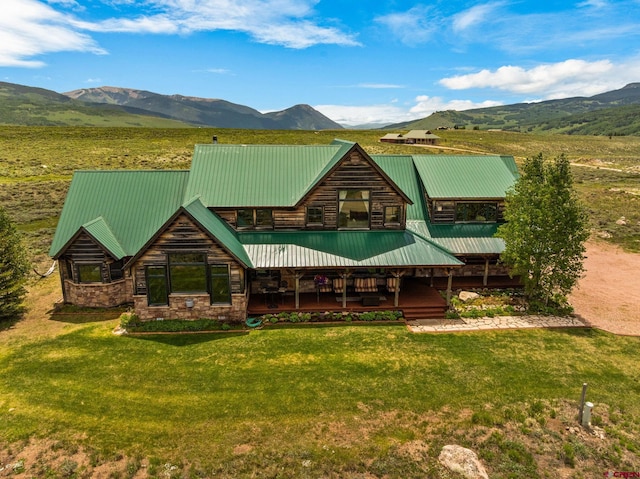 322 Wapiti Ln, Crested Butte, CO 81224 - rear view of property with a mountain view, a yard, stone siding, and a metal roof