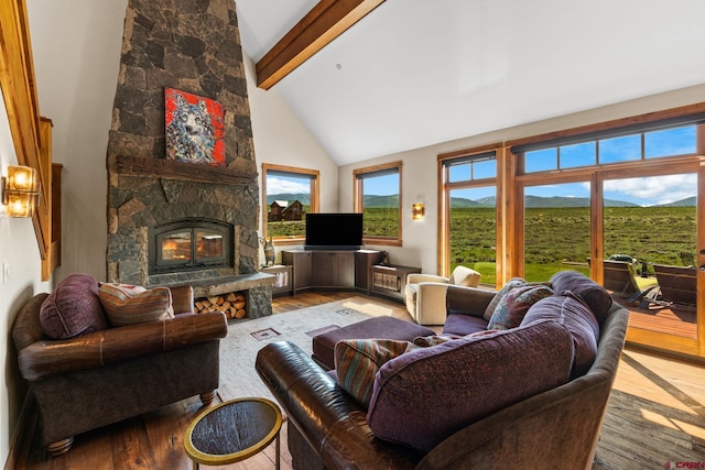 322 Wapiti Ln, Crested Butte, CO 81224 - living room featuring wood finished floors, beam ceiling, high vaulted ceiling, and a stone fireplace