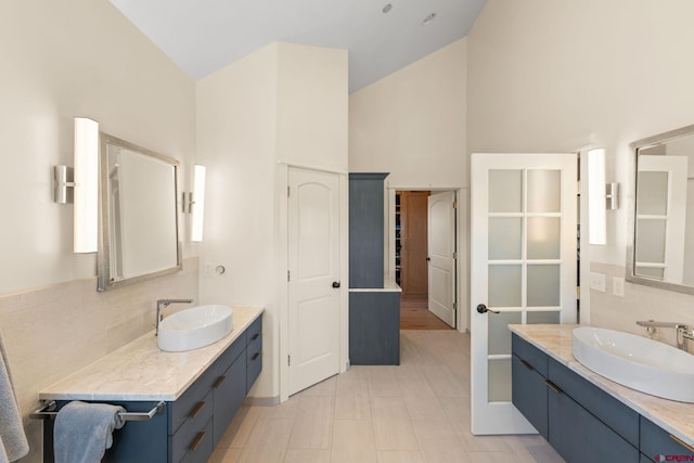 322 Wapiti Ln, Crested Butte, CO 81224 - bathroom with tasteful backsplash, high vaulted ceiling, and two vanities