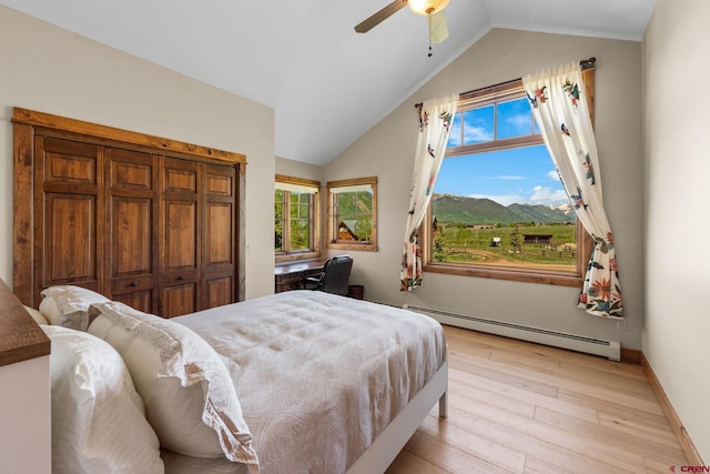 322 Wapiti Ln, Crested Butte, CO 81224 - bedroom featuring a baseboard heating unit, multiple windows, light wood finished floors, lofted ceiling, and ceiling fan