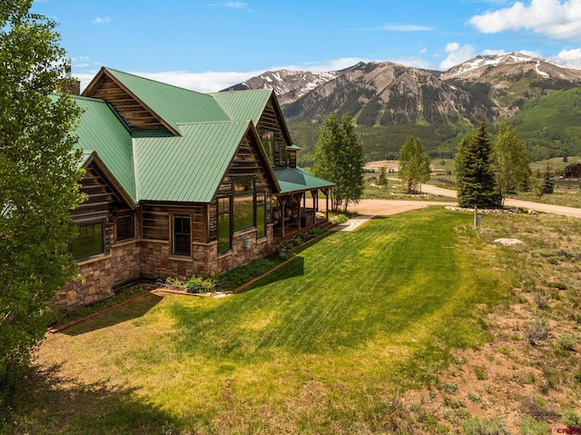322 Wapiti Ln, Crested Butte, CO 81224 - exterior space featuring a yard, a mountain view, stone siding, and a metal roof