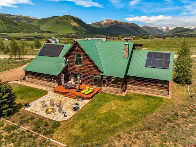 322 Wapiti Ln, Crested Butte, CO 81224 - rear view of property featuring a patio area, roof mounted solar panels, and a lawn