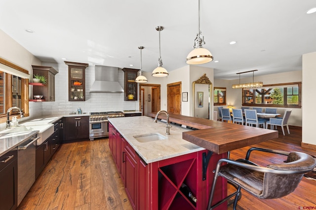 322 Wapiti Ln, Crested Butte, CO 81224 - kitchen with wall chimney range hood, stainless steel appliances, dark wood finished floors, open shelves, and recessed lighting