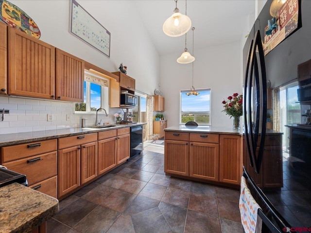 12689 6100th Rd, Montrose, CO 81401 - kitchen featuring high vaulted ceiling, black appliances, decorative backsplash, decorative light fixtures, and healthy amount of natural light