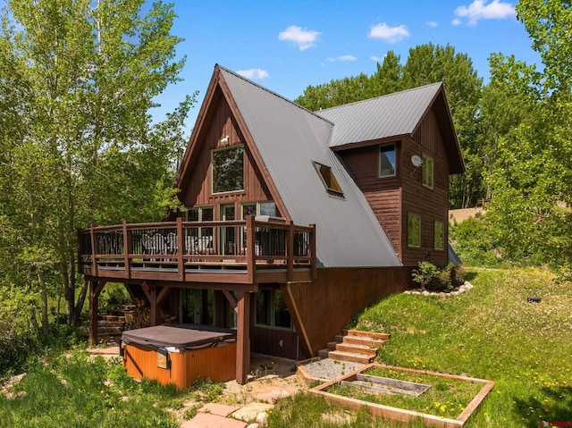 41 Cinnamon Mountain Rd, Mount Crested Butte, CO 81225 - rear view of house featuring a hot tub, a wooden deck, a lawn, and a metal roof