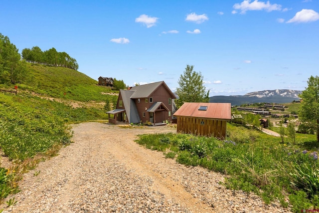 41 Cinnamon Mountain Rd, Mount Crested Butte, CO 81225 - view of side of home with driveway, a mountain view, and an outdoor structure