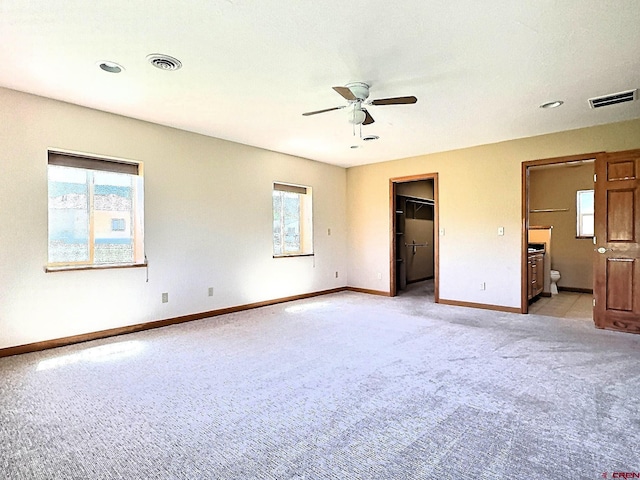 404 SE Birdie Cir, Cedaredge, CO 81413 - unfurnished bedroom featuring light carpet, connected bathroom, a spacious closet, ceiling fan, and recessed lighting