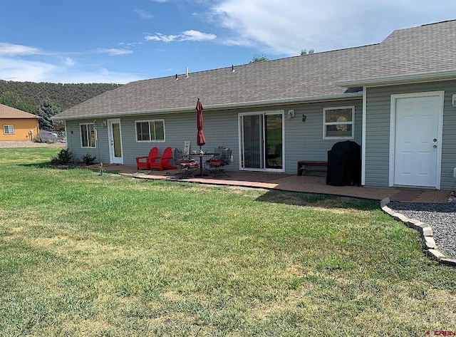 404 SE Birdie Cir, Cedaredge, CO 81413 - rear view of property featuring a yard, a patio, and a shingled roof