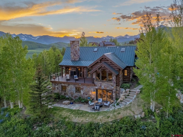 3 Summit Ct, Mount Crested Butte, CO 81225 - back of property with a balcony, outdoor lounge area, a patio area, a chimney, and a mountain view
