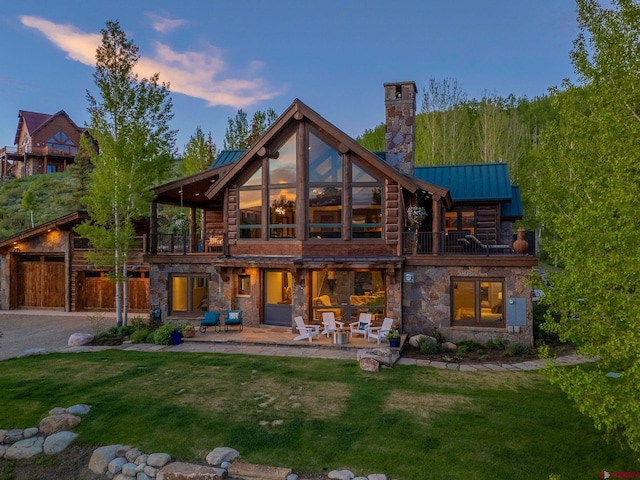3 Summit Ct, Mount Crested Butte, CO 81225 - rear view of property featuring a balcony, a chimney, stone siding, a standing seam roof, and a yard