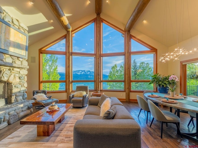3 Summit Ct, Mount Crested Butte, CO 81225 - living room featuring beam ceiling, a chandelier, wood-type flooring, high vaulted ceiling, and a stone fireplace