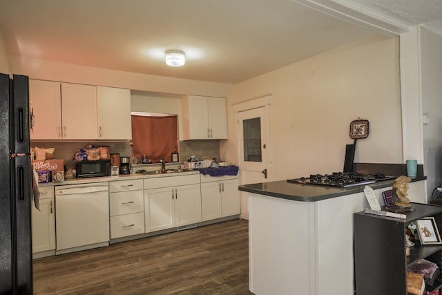 1132 Robinson Ave, Trinidad, CO 81082 - kitchen with black appliances, white cabinets, dark wood-style floors, decorative backsplash, and a peninsula