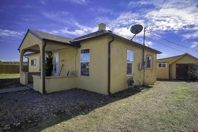 1132 Robinson Ave, Trinidad, CO 81082 - view of side of home with a chimney, stucco siding, and a storage shed