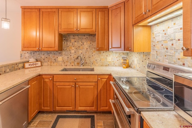 20 Hunter Hill Rd Unit 110, Mount Crested Butte, CO 81225 - kitchen featuring appliances with stainless steel finishes, light stone counters, tasteful backsplash, hanging light fixtures, and brown cabinets