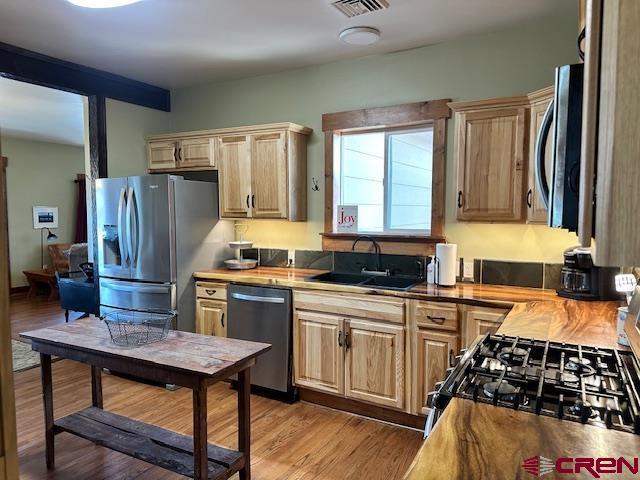 115 S Linden, Cortez, CO 81321 - kitchen with appliances with stainless steel finishes, light wood-style floors, and light brown cabinets