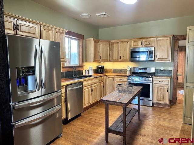 115 S Linden, Cortez, CO 81321 - kitchen with stainless steel appliances, light brown cabinetry, and light wood-style flooring