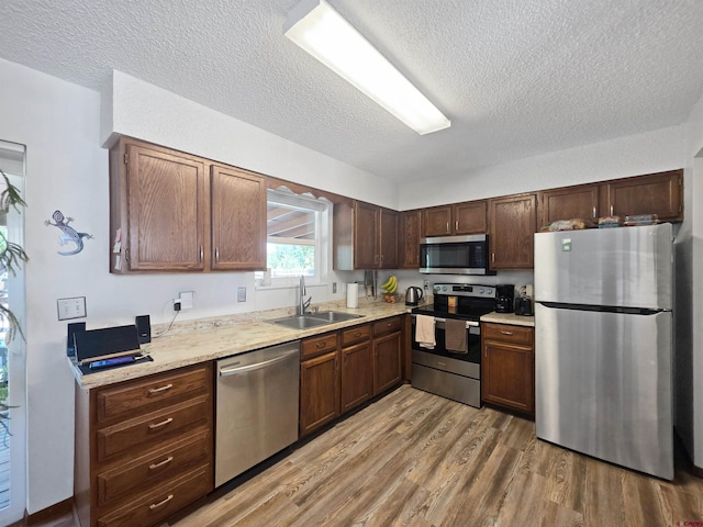 613 N Colorado St, Cortez, CO 81321 - kitchen with stainless steel appliances, light wood-style floors, a textured ceiling, and light countertops