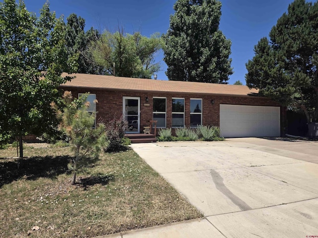 613 N Colorado St, Cortez, CO 81321 - ranch-style home with an attached garage, concrete driveway, and brick siding