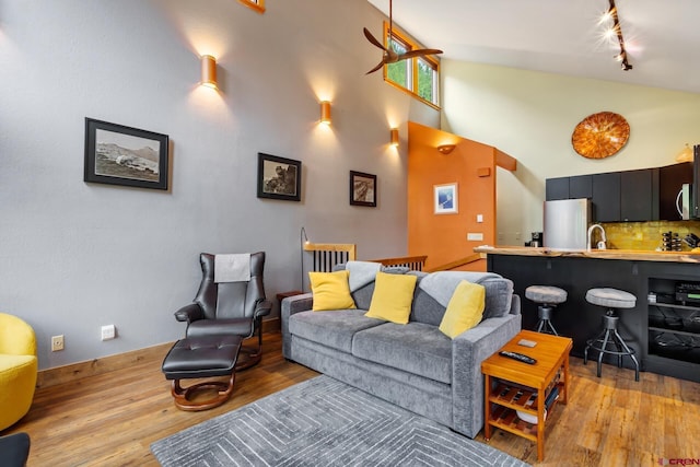 333 S Fir St Unit 101, Telluride, CO 81435 - living room featuring light wood-style flooring, rail lighting, and a high ceiling