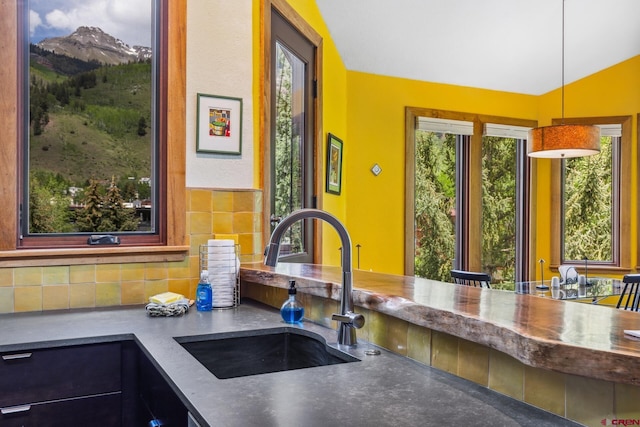 333 S Fir St Unit 101, Telluride, CO 81435 - kitchen featuring backsplash, decorative light fixtures, lofted ceiling, and a mountain view