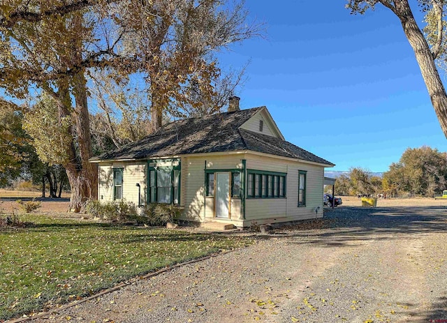 18551 F Rd, Delta, CO 81416 - view of front of home with a chimney, driveway, and a front yard