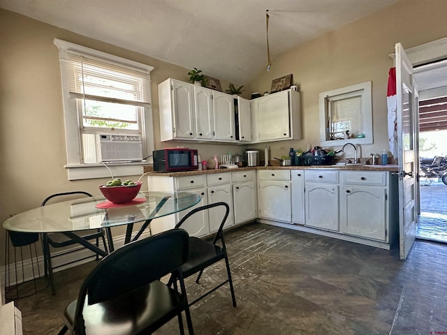 18551 F Rd, Delta, CO 81416 - kitchen featuring black microwave, white cabinets, vaulted ceiling, and cooling unit