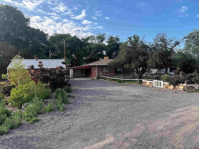 20114 Austin Rd, Austin, CO 81410 - view of front of house with a chimney, driveway, and an attached carport