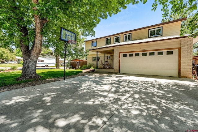 1736 Forest Ave, Durango, CO 81301 - view of front of house featuring brick siding, concrete driveway, a garage, a front lawn, and a metal roof