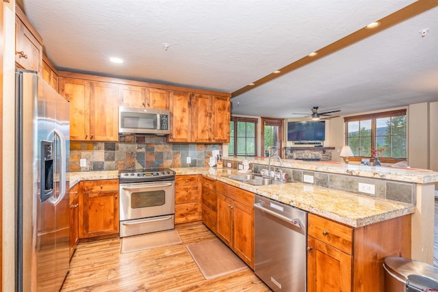24 Sheol St Unit 202, Durango, CO 81301 - kitchen featuring stainless steel appliances, a peninsula, light wood finished floors, backsplash, and a ceiling fan