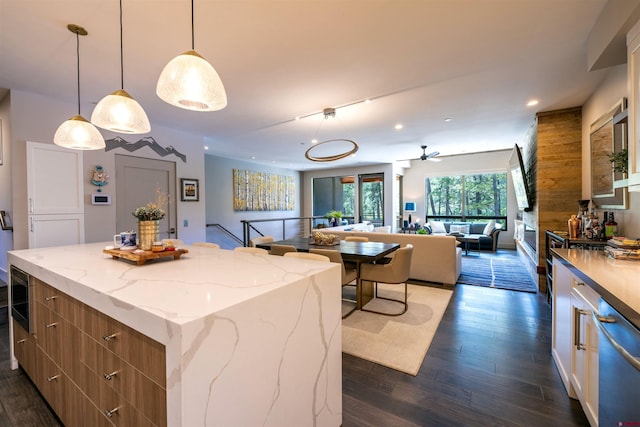928 Twin Buttes Ave, Durango, CO 81301 - kitchen with open floor plan, dark wood-style floors, a kitchen island, recessed lighting, and light stone countertops
