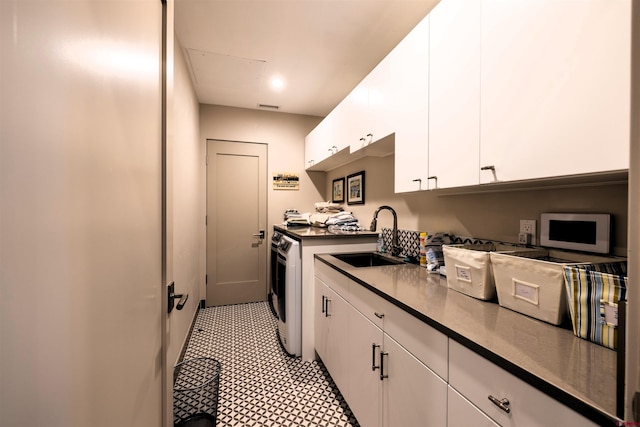 928 Twin Buttes Ave, Durango, CO 81301 - kitchen with white cabinets, washing machine and clothes dryer, and dark countertops