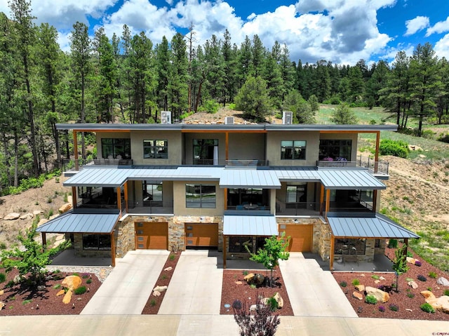 928 Twin Buttes Ave, Durango, CO 81301 - modern home featuring stone siding, a standing seam roof, a garage, driveway, and a metal roof