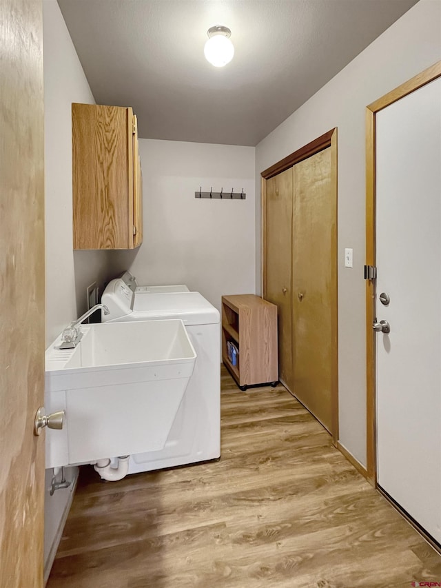 14245 Rd 21, Cortez, CO 81321 - laundry room with cabinet space, independent washer and dryer, and light wood-style flooring