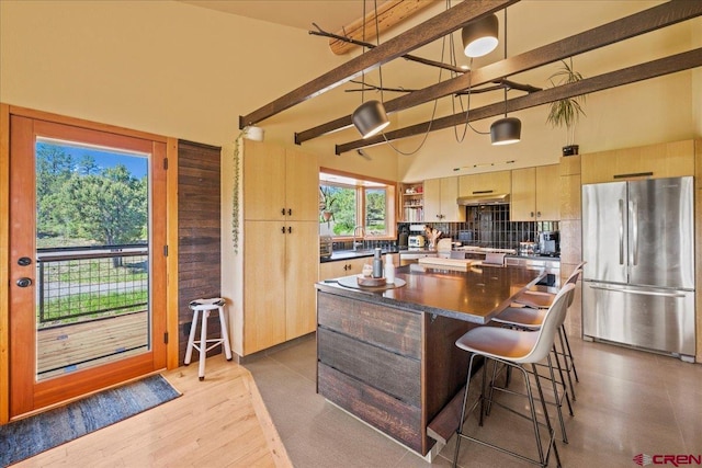 122 Juniper Rd, Ridgway, CO 81432 - kitchen featuring freestanding refrigerator, dark countertops, a kitchen island, backsplash, and a breakfast bar area