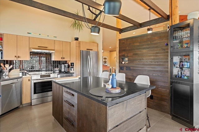 122 Juniper Rd, Ridgway, CO 81432 - kitchen with stainless steel appliances, light brown cabinetry, a towering ceiling, under cabinet range hood, and light tile patterned floors